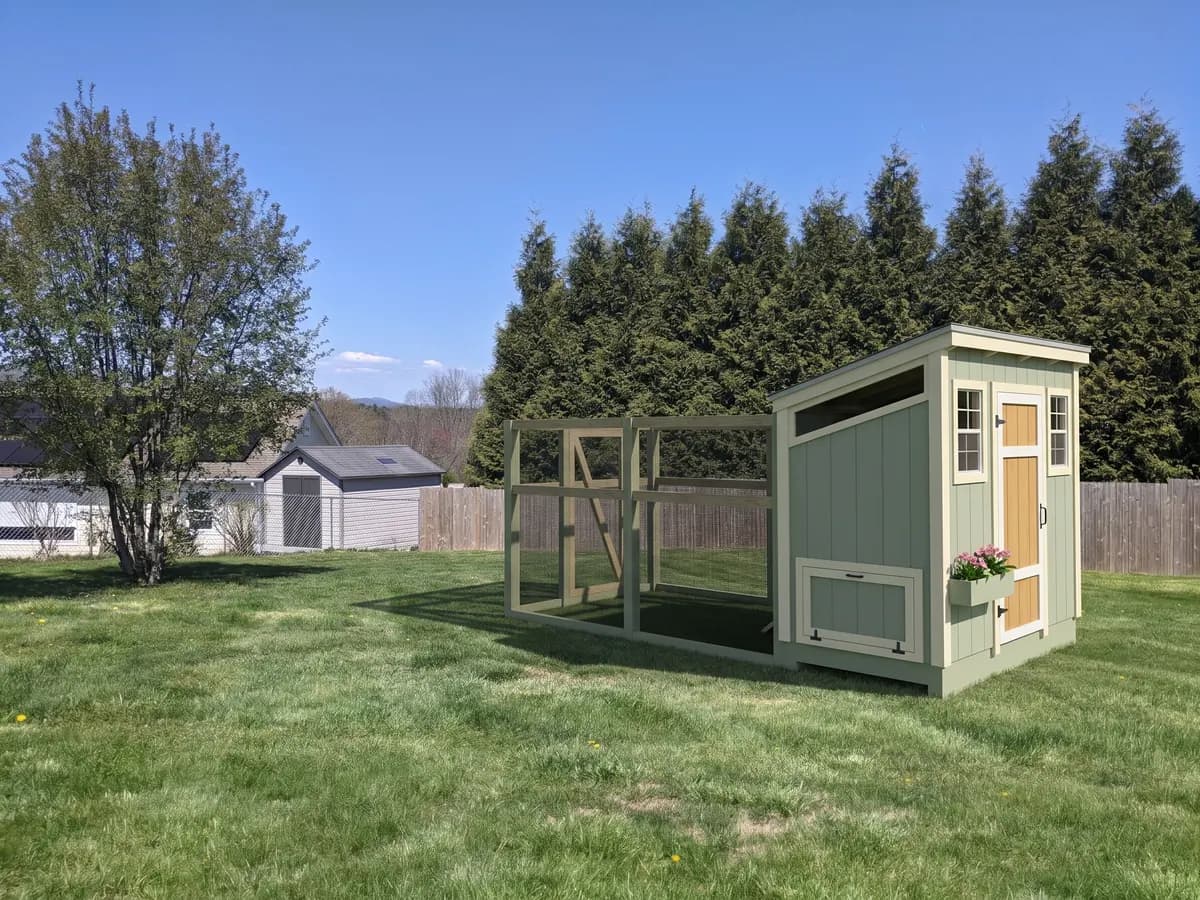 Walk-in coop with attached run in a backyard (representative image)